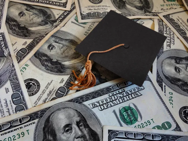 graduation cap on money